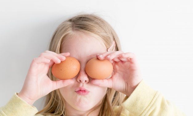 Girl holding eggs to her eyes.