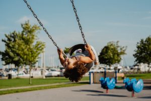 A child playing on a swing.