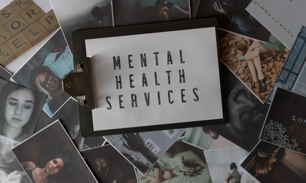 Photos scattered on a surface with a clipboard on top and a piece of paper that reads "Mental Health Services"