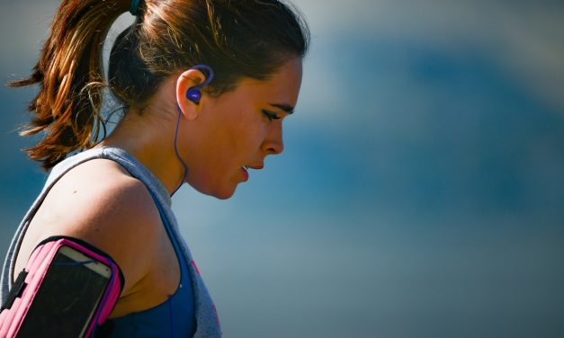 Woman wearing armband and blue earphones