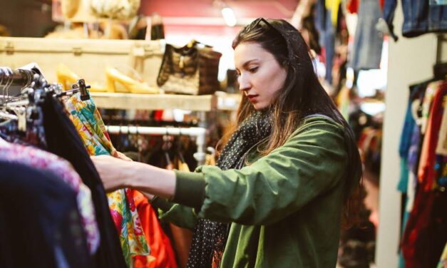 A person shopping for second hand fashion in a charity shop
