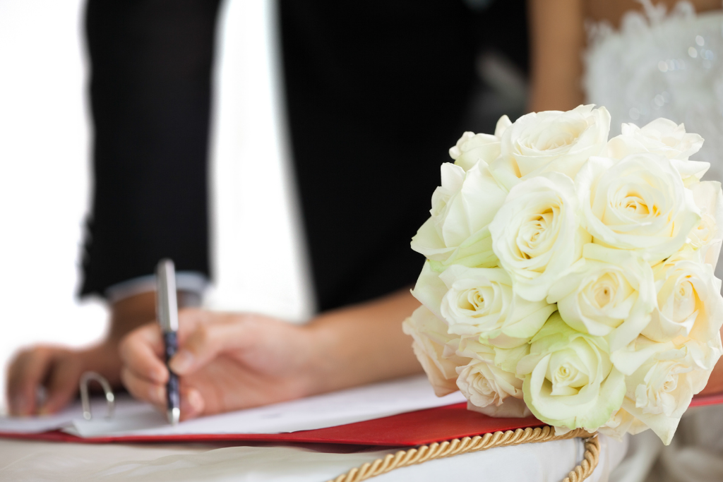 Signing wedding register, bouquet of white roses
