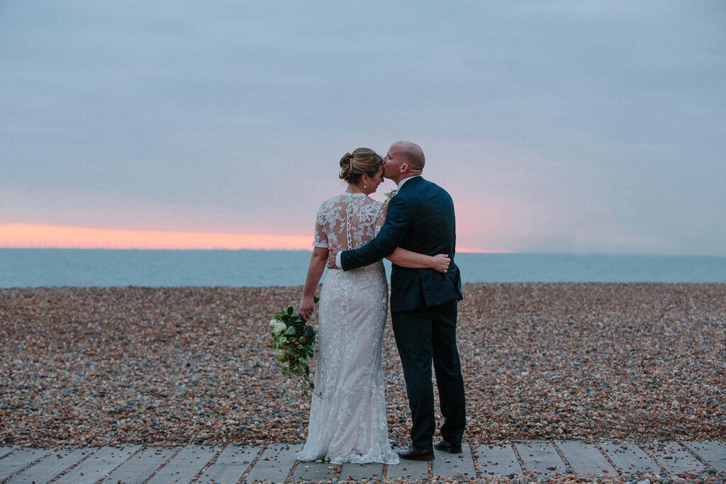 Wedding ceremony in East Sussex: couple standing together as sun sets