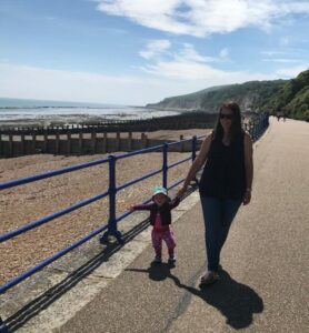 A woman and toddler walk along the promenade on Eastbourne seafront