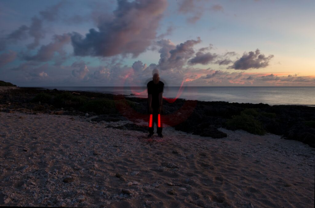 Man standing in the dark on a beach.