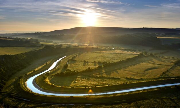 the sun setting over the winding meanders of the Cuckmere Valley in East Sussex