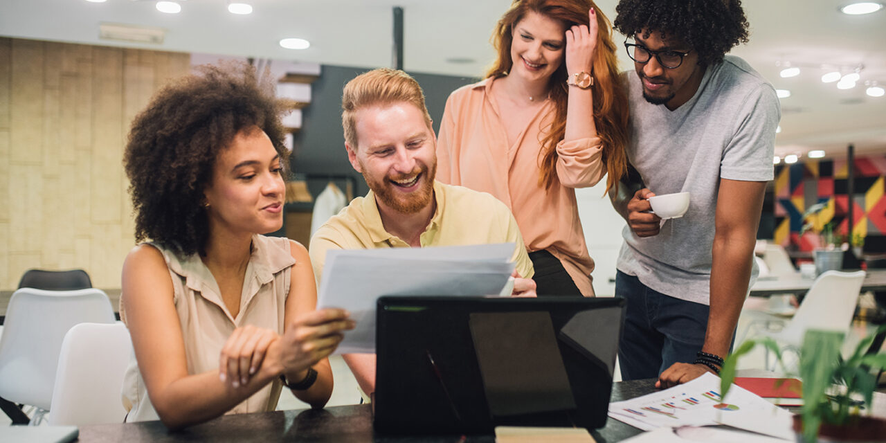 group of people working in office at a laptop