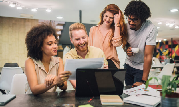 group of people working in office at a laptop