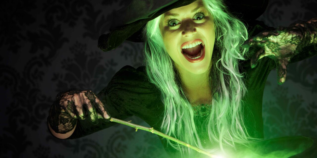 woman dressed as witch casts a spell over a cauldron