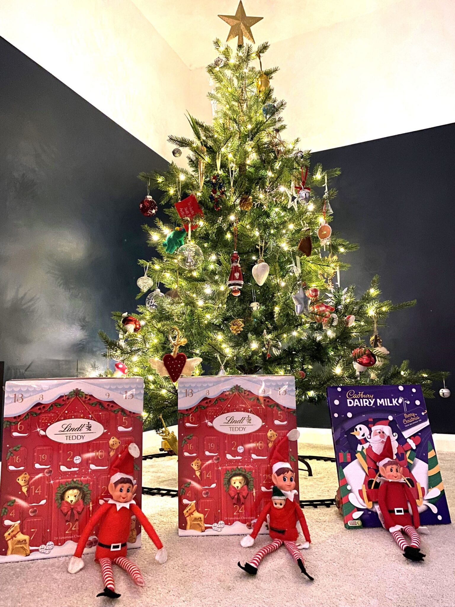 Elf on the Shelf with advent calendars in front of the Christmas tree