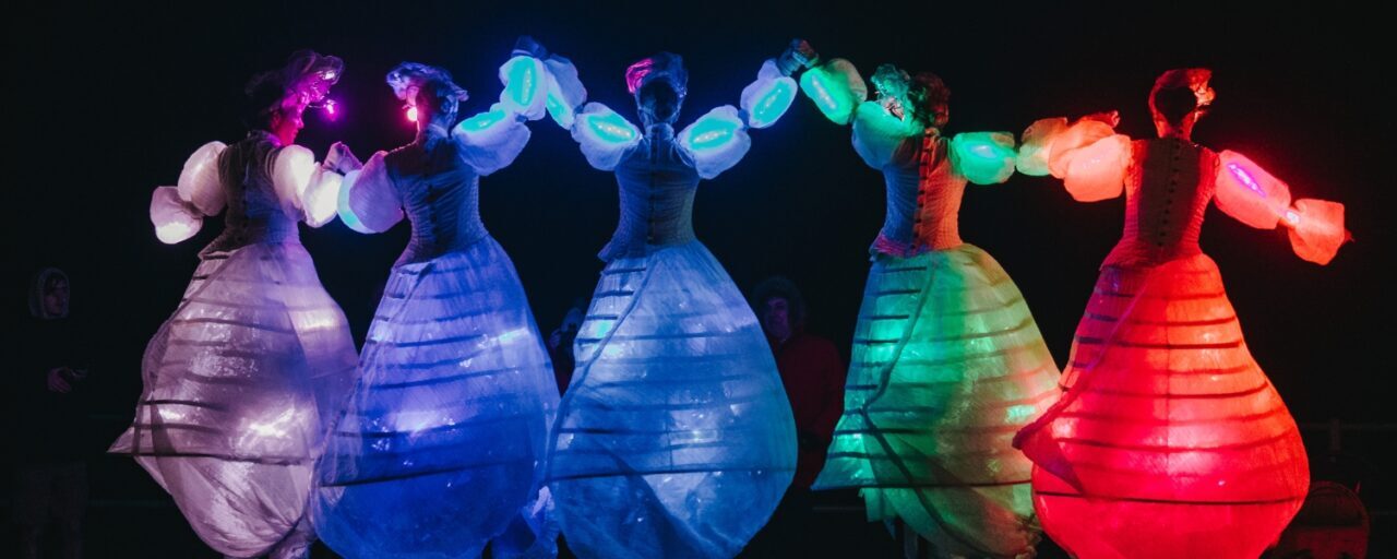 ladies dancing in coloured illuminated dresses