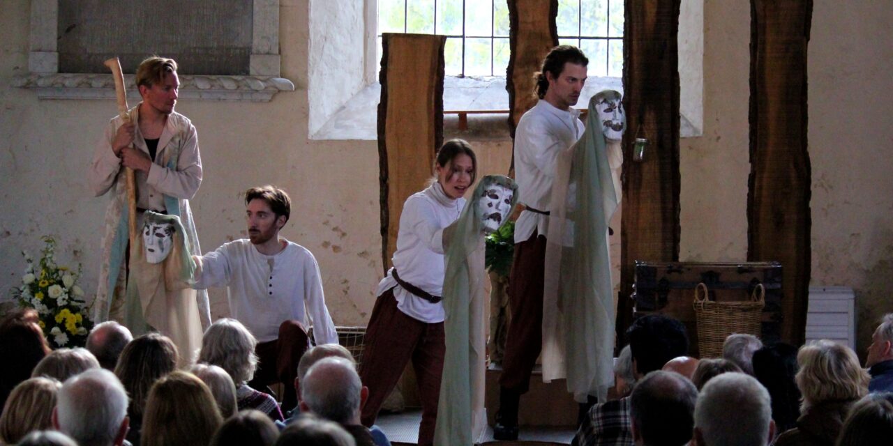 actors in Elizabethan dress holding white masks standing in front of the audience