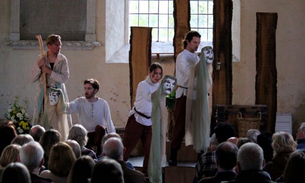 actors in Elizabethan dress holding white masks standing in front of the audience