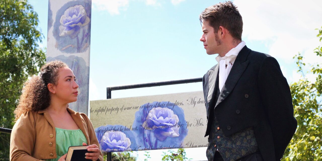 A female and male actor in Regency dress performing outside