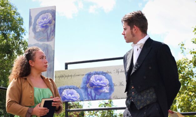 A female and male actor in Regency dress performing outside