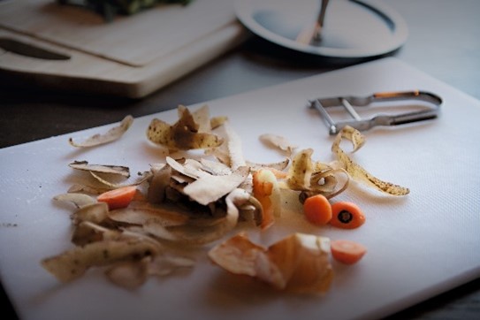 Peelings and scraps of food on a kitchen work surface.